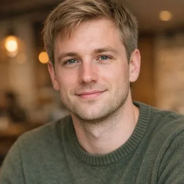 Young man, ash-blonde hair, light eyes, olive knit sweater, café background